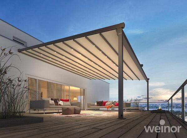 Moderne Terrasse mit stilvollem Terrassendach und gemütlicher Outdoor-Sitzgruppe bei Sonnenuntergang.