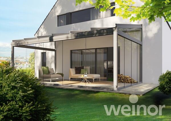 Moderne Terrassenüberdachung aus Glas am Einfamilienhaus mit stilvoller Gartenlounge.
