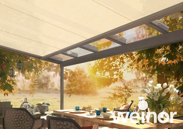 Überdachte Terrasse im Garten mit modernem Glasdach, gedecktem Tisch und Sonnenlicht.